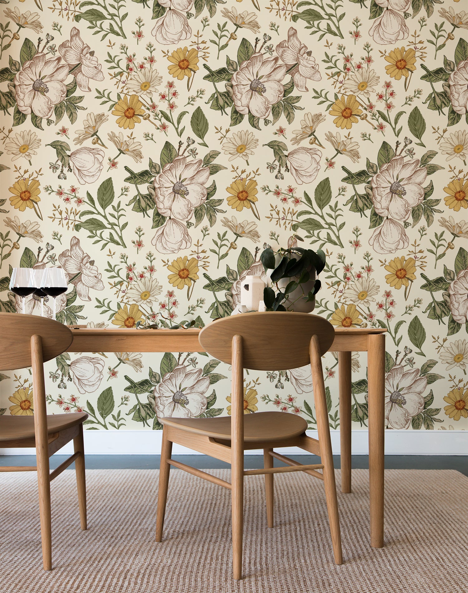 A dining area with natural wood furniture against a wall covered in Floral Wallpaper - Sunny, which displays a vibrant array of hand-drawn flowers in yellows and greens on a cream background, creating a fresh and inviting botanical theme.