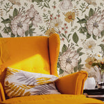 A cozy reading corner featuring a bold yellow armchair against the Floral Wallpaper - Sunny, which complements the chair's vibrant color with its cheerful and sunny botanical pattern, enhancing the warmth and inviting atmosphere of the room.
