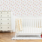A nursery room adorned with the Gentle Floral Wallpaper, which features an array of small, pastel pink and yellow flowers that bring a serene and cheerful ambiance to the space. The floral theme is perfectly suited for creating a soothing environment for children