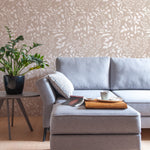A modern living room featuring Pressed Branches Wallpaper with a delicate white botanical pattern on a beige background. The room includes a gray sofa, a side table with a potted plant, and a wooden floor.A modern living room featuring Pressed Branches Wallpaper with a delicate white botanical pattern on a beige background. The room includes a gray sofa, a side table with a potted plant, and a wooden floor.