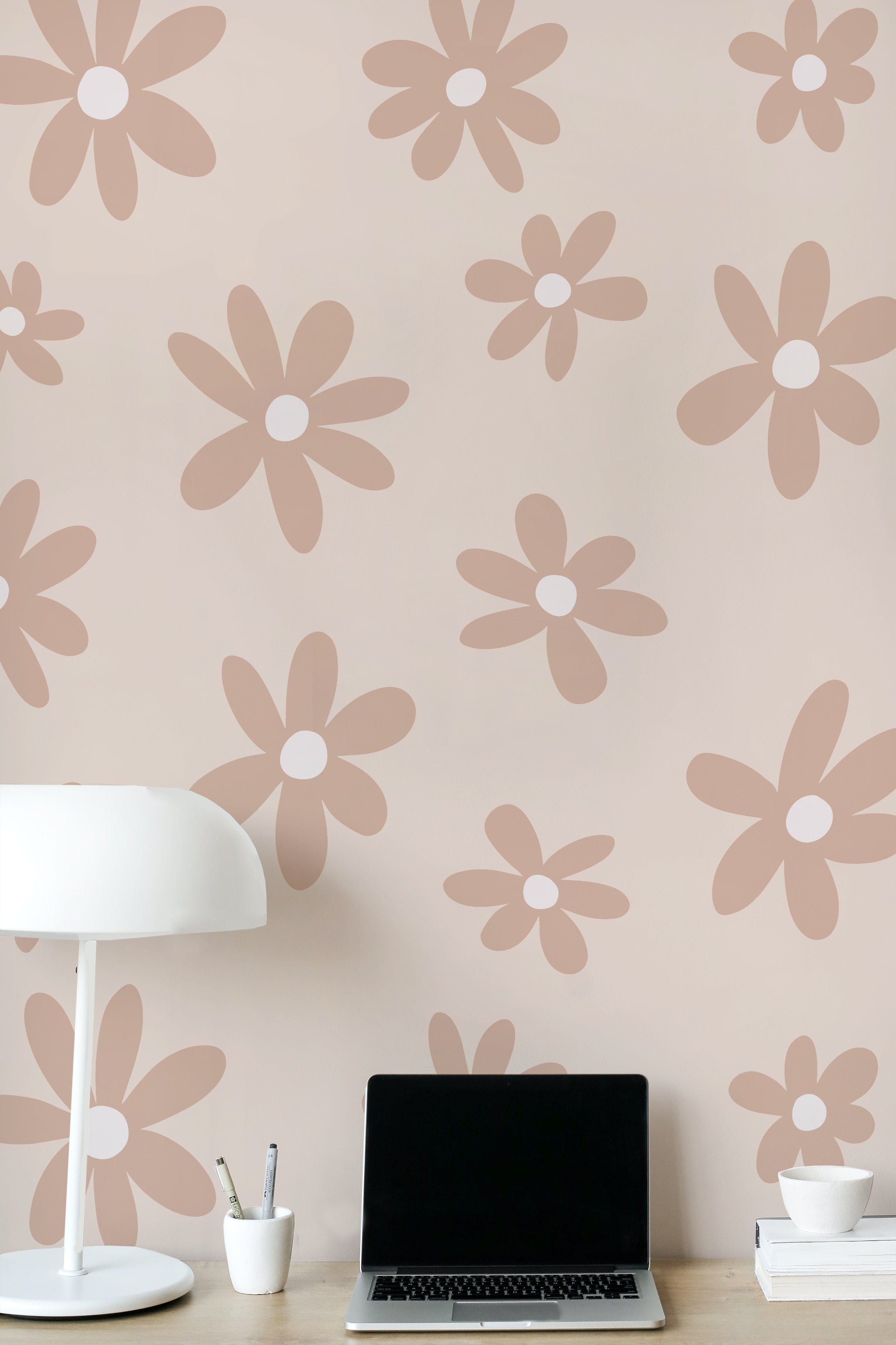 A modern workspace featuring a laptop on a wooden desk, a white lamp, and Simple Mauve Floral Wallpaper in the background. The large mauve flowers on a light beige background create a calming and stylish backdrop for productivity.