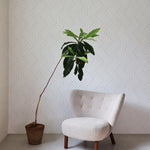 Modern Braids Wallpaper in a minimalist living room with a cozy chair and potted plant.