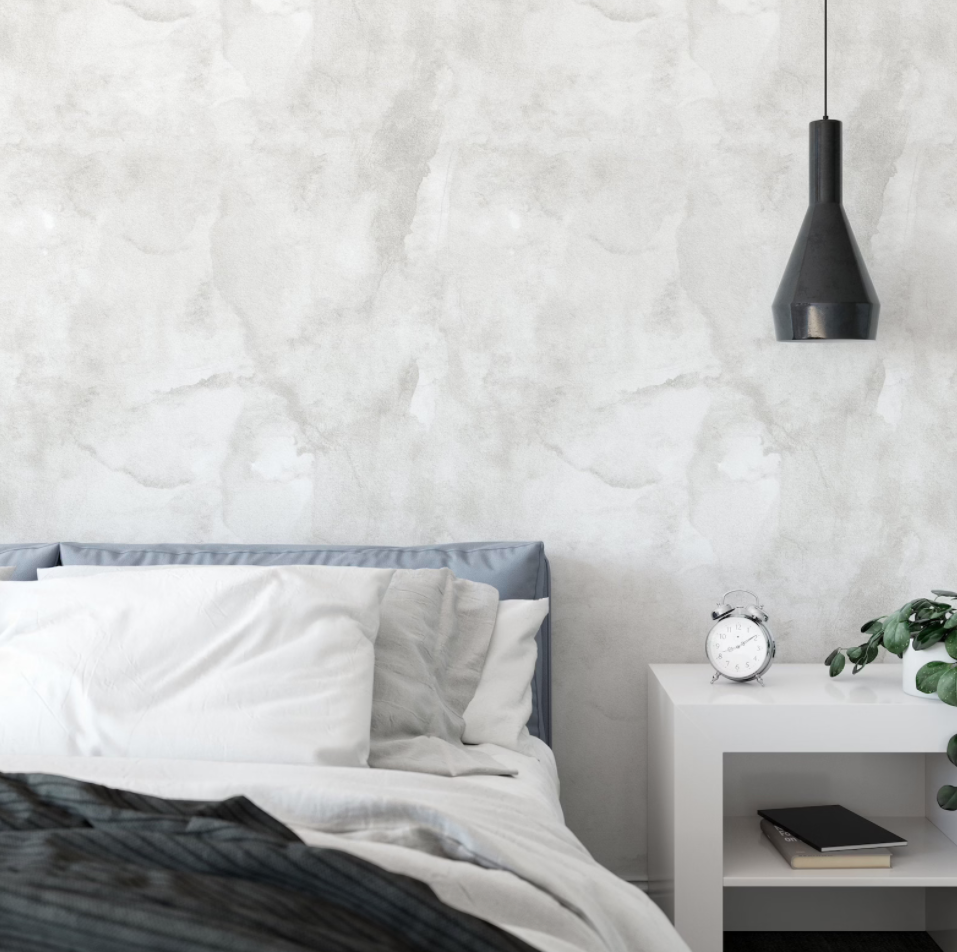 Modern minimalist bedroom featuring Grey Limewash Wallpaper that offers a subtle, textured backdrop to a cozy bed with crisp white linens and a sleek bedside setup