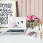 Creative workspace enhanced by Pink Textured Striped Wallpaper, providing a soft pink striped backdrop that contrasts beautifully with a vibrant bouquet of roses, inspiring quotes, and a sleek laptop setup on a white desk