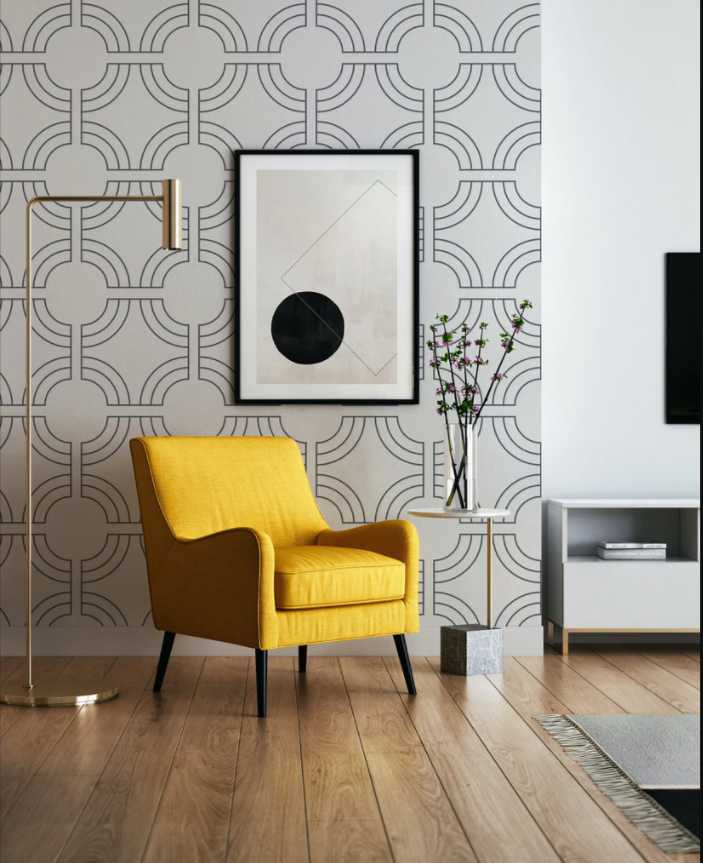 A bright room is adorned with the Geometric Wallpaper, providing an elegant and dynamic backdrop for a mustard yellow armchair. The wallpaper's strong lines and curves form a striking contrast with the vibrant furniture and minimalist decor, illustrating a perfect blend of form and color.