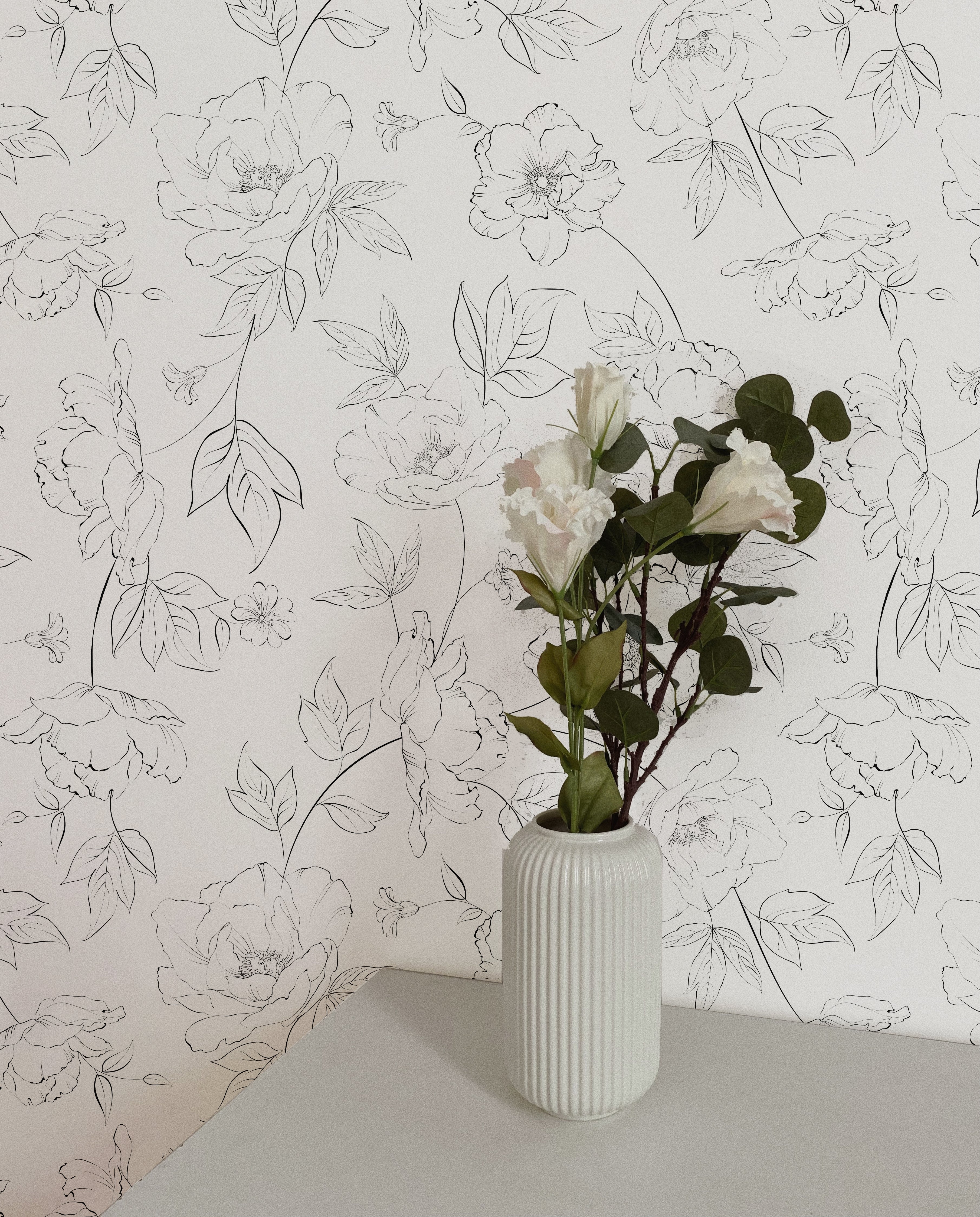 Elegant white vase with fresh flowers set against the Dainty Floral Line Wallpaper, emphasizing the detailed floral line art