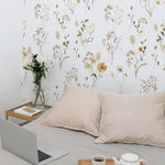A minimalist bedroom scene accentuated by the Delicate Floral Wallpaper, providing a gentle and soothing environment for relaxation and work, with subtle botanical designs