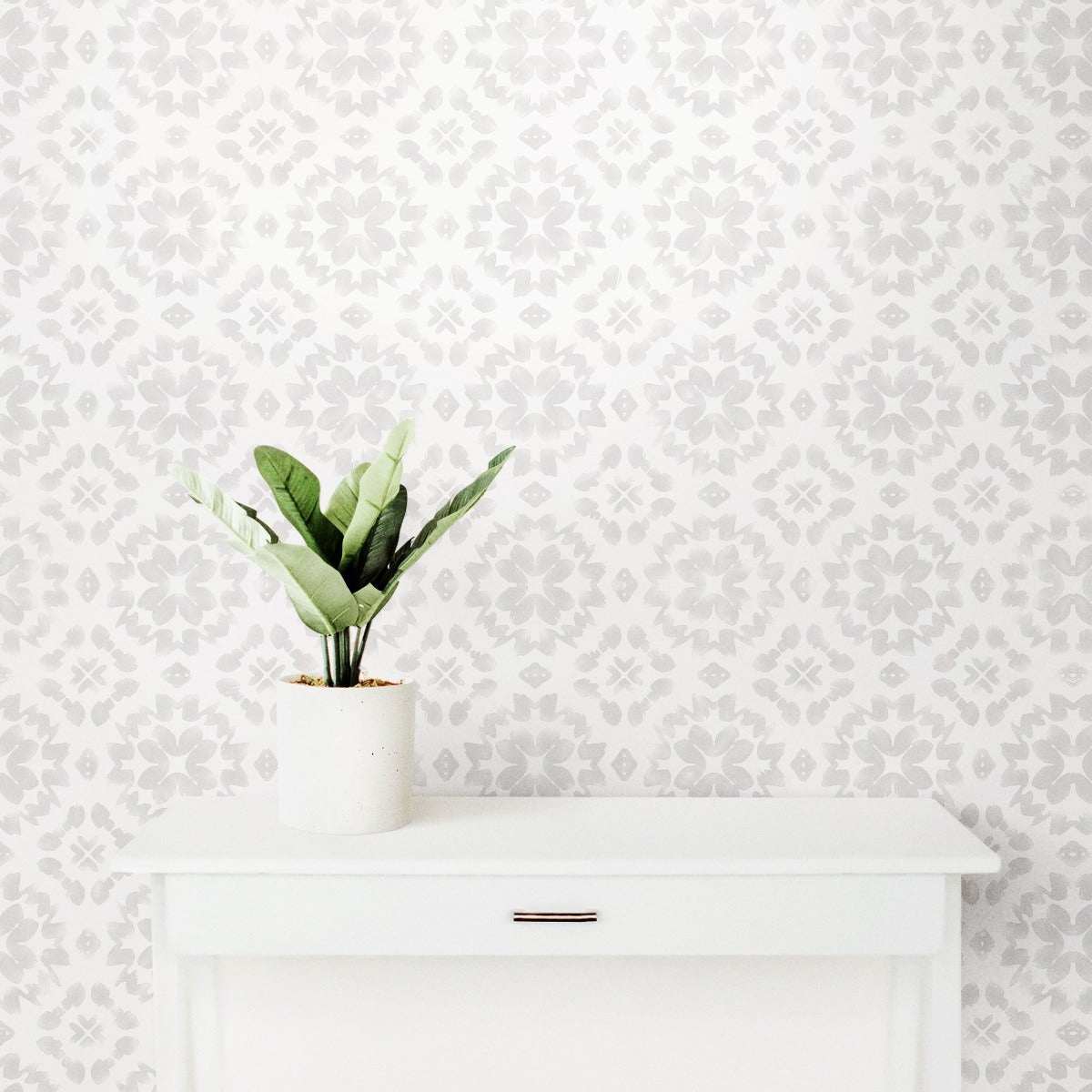 The 'Geometric Watercolor - Muskoka Snow' wallpaper applied in a clean, bright room, complementing a white mantlepiece with a potted plant, creating a minimalist and tranquil space