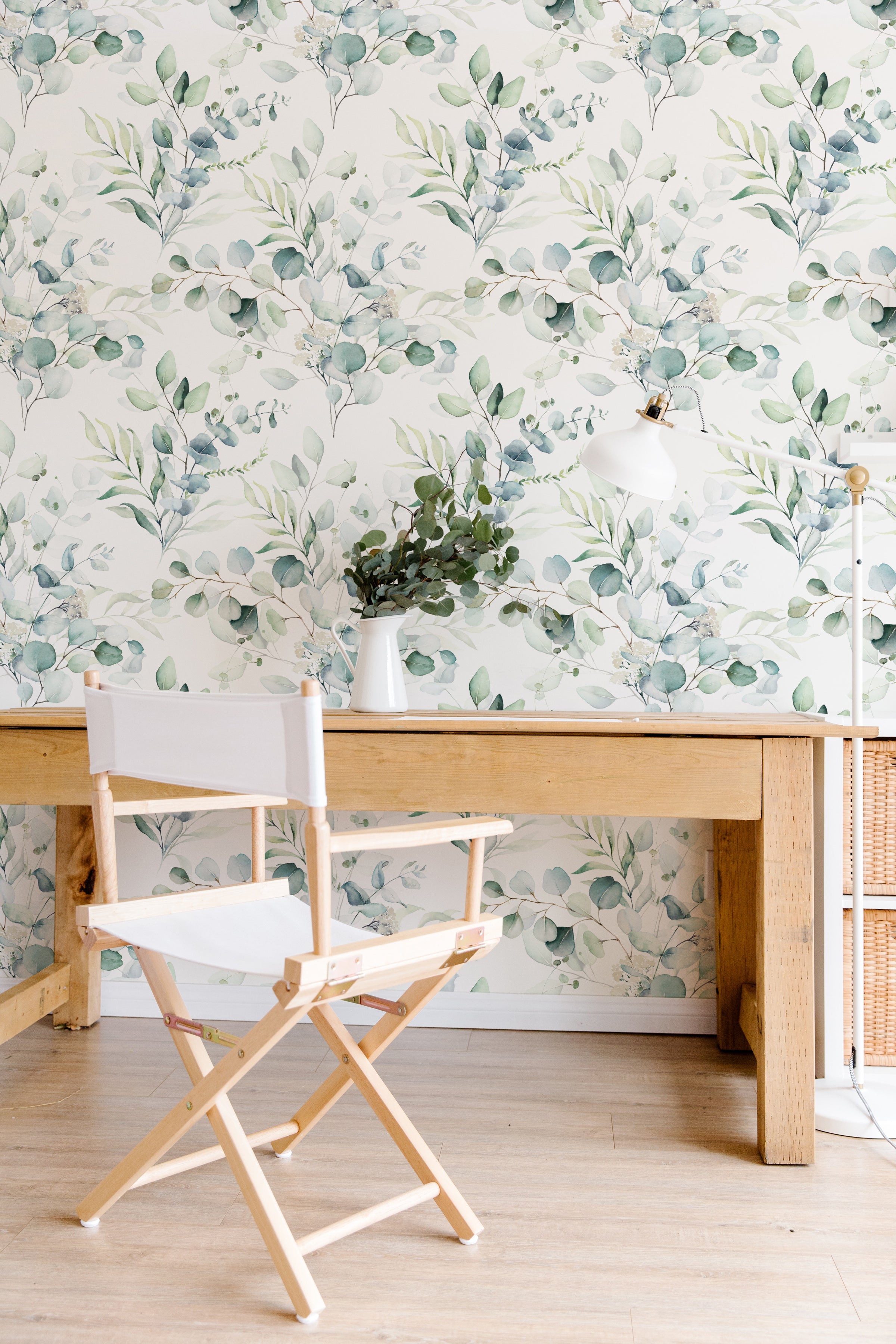A bright and airy workspace with Green Leaves and Branches Wallpaper, wooden desk, and director's chair creating a refreshing indoor atmosphere.