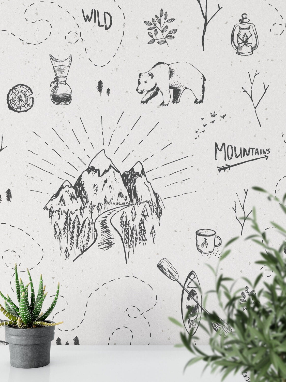 A whimsically designed bedroom with the Big Adventure Kids Wallpaper depicting a black and white illustrated scene of outdoor activities and wildlife, including bears, tents, mountains, and trees, which creates a playful and adventurous vibe.