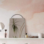 A closer view of the abstract Hand Painted Mural Wallpaper in a bathroom setup, exhibiting a blush watercolor effect, providing a subtle yet artistic backdrop to the modern white sink and sleek bathroom accessories.