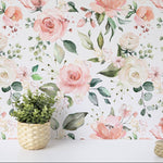 A lifelike rendering of the Pink and Cream Rose Wallpaper applied on a wall, complemented by a wicker planter with lush green foliage. The intricate floral design brings a burst of spring into the room, creating an inviting and romantic atmosphere.