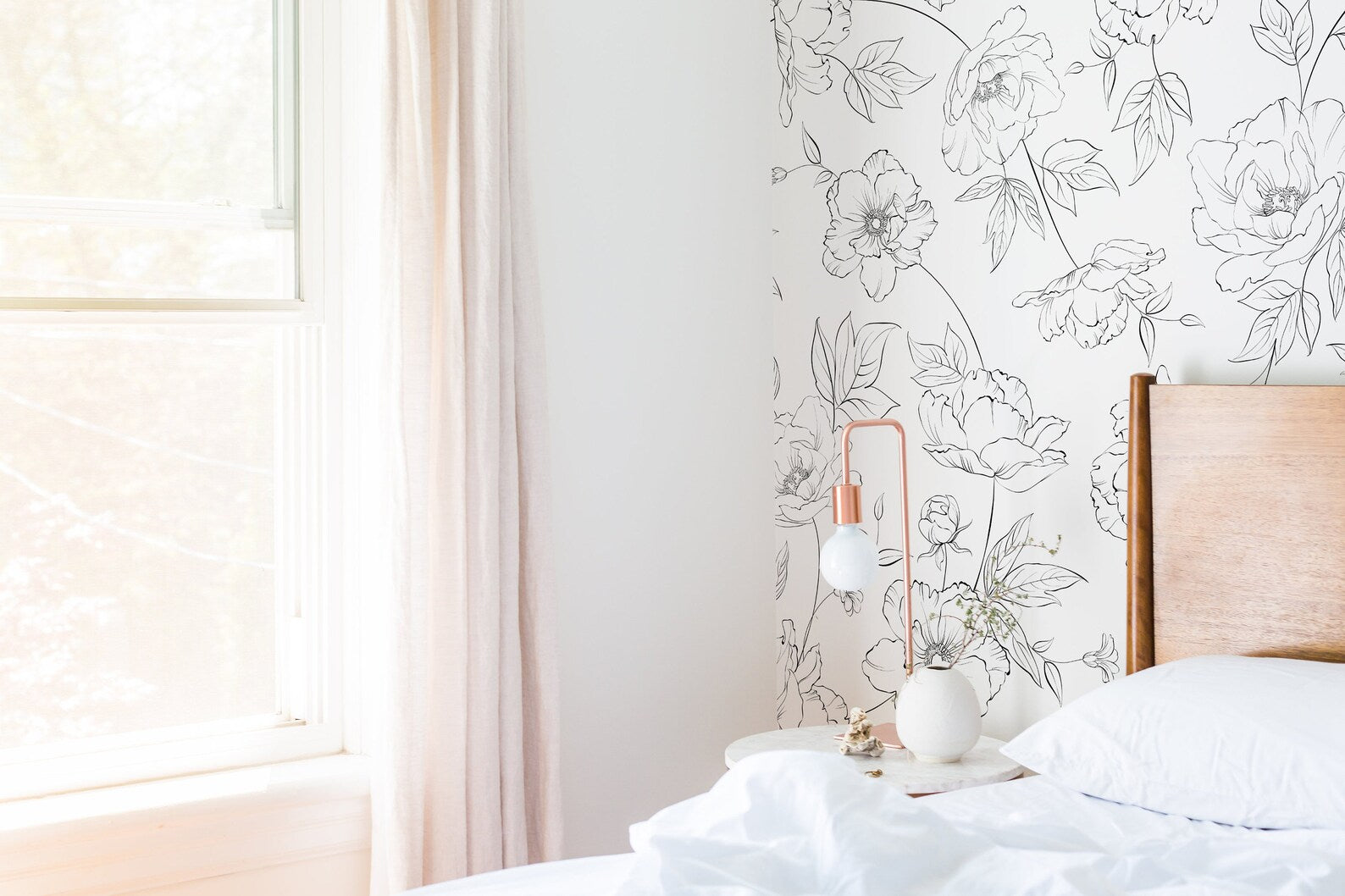 Bright bedroom with Dainty Floral Line Wallpaper - Extra Large featuring a black and white floral line art design on a light background, creating a fresh and elegant atmosphere with a wooden bed and minimalist decor.