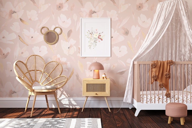 A charming nursery featuring the Prettiest in Pink Floral Wallpaper, with soft pink blooms and delicate foliage on a light background, complemented by a whimsical rattan peacock chair, a delicate white canopy over a crib, and playful children's decor, creating a serene and enchanting space for a little one.
