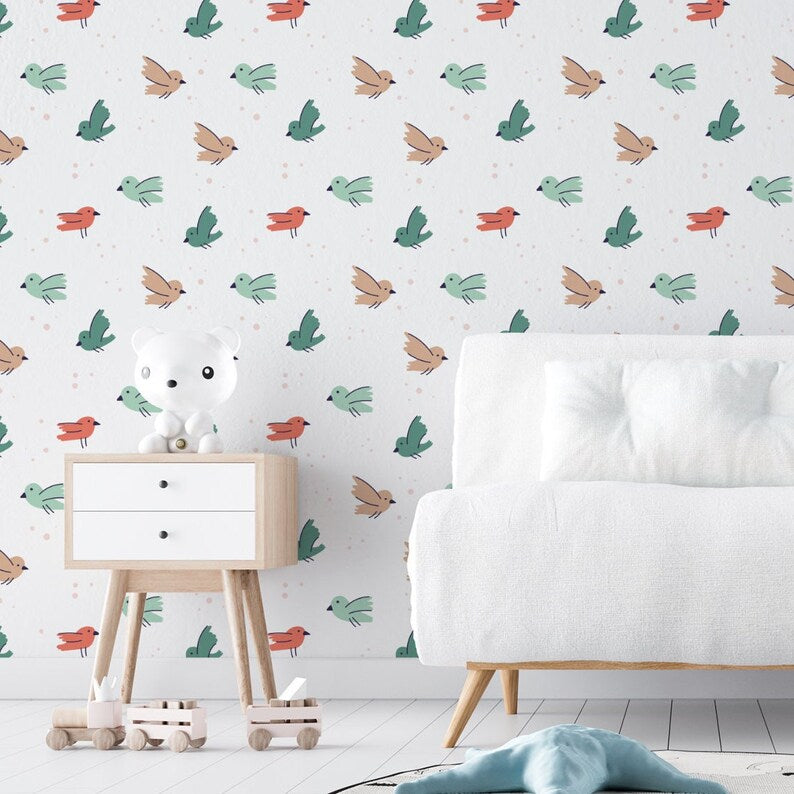 Stylish children's room decorated with green and orange bird wallpaper, white furniture, and plush toys.