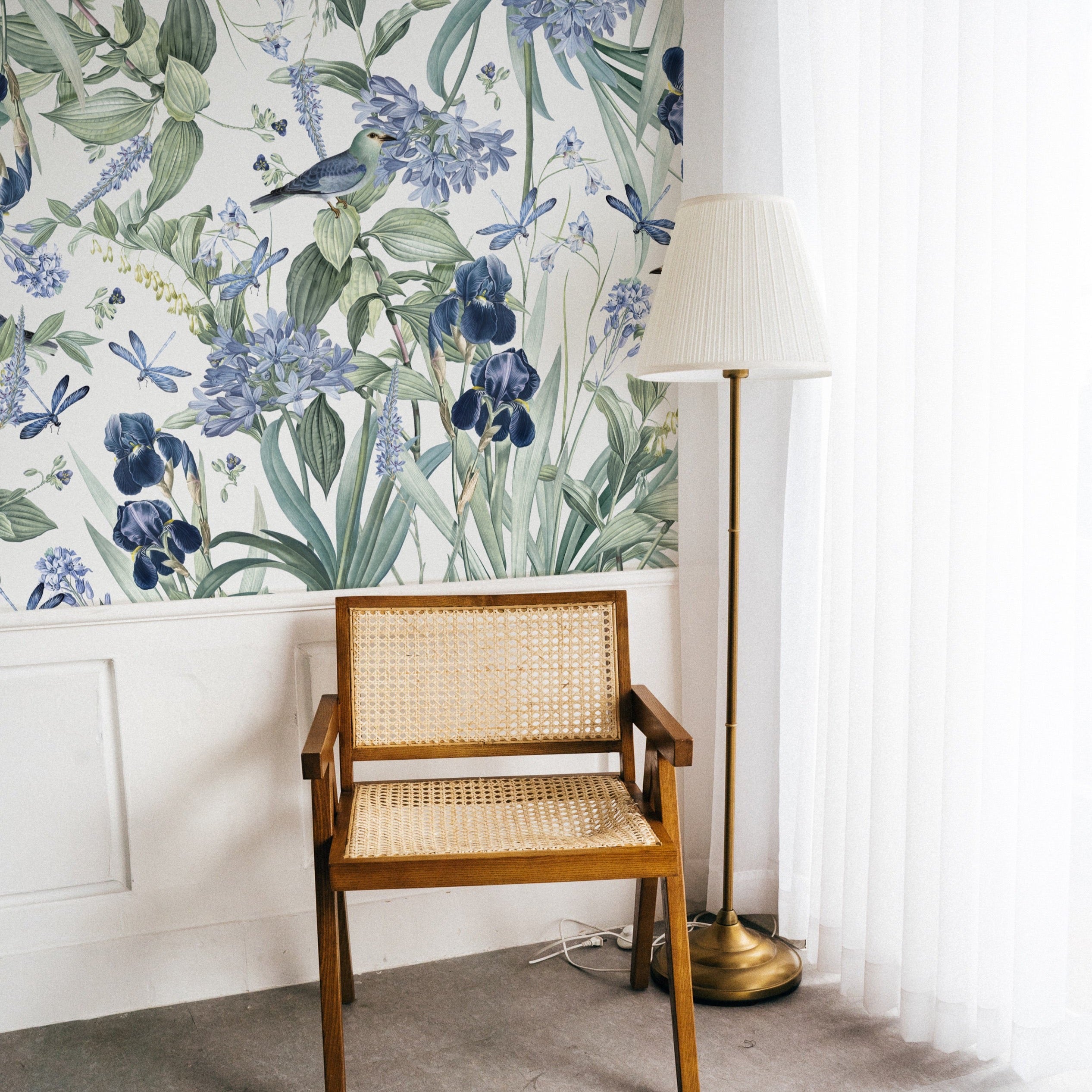 A cozy reading nook with the 'Mint Floral Wallpaper - 50"' adorning the wall, accompanied by a vintage wooden chair with wicker seating and a classic floor lamp, creating an inviting and warm atmosphere.