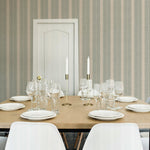 Elegant dining setting with 'Burlap Striped Wallpaper' providing a textured backdrop of vertical stripes, blending seamlessly with a sophisticated table arrangement and white chairs