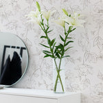 Bright and airy corner with a round mirror reflecting a vase of lilies against the backdrop of Dainty Floral Line Wallpaper