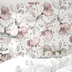 A cozy bedroom featuring Pink Watercolour Floral Wallpaper with delicate pink and grey watercolor flowers and leaves, creating a serene and elegant ambiance